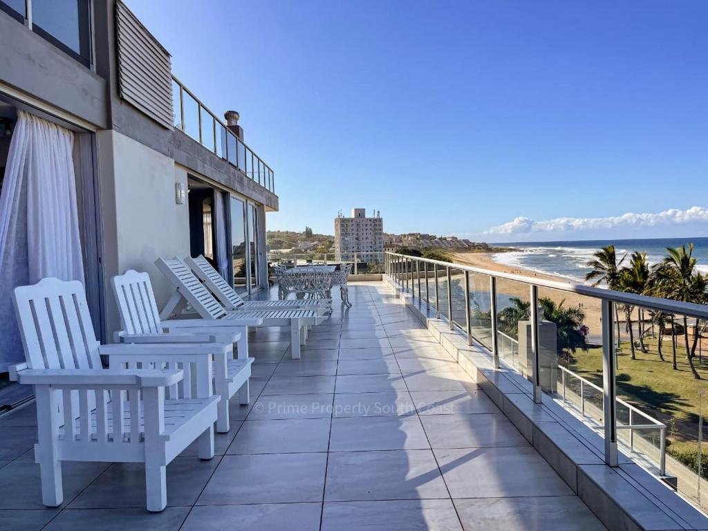 a balcony with white chairs overlooking the ocean at Rondevoux 17 in Margate