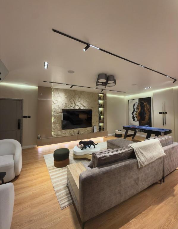 a living room with a couch and a table at Premium 2 Bedroom Maisonette with Ps5 & Pool in Lekki
