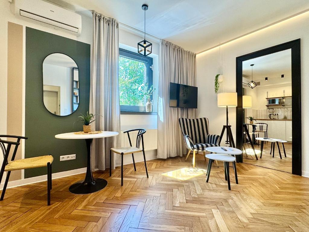 a living room with a table and chairs and a mirror at Apartamenty Młyńska 3A in Gliwice