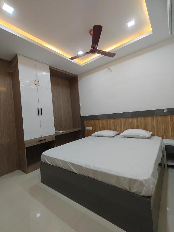 a bedroom with a bed and a ceiling fan at Anand palace lodge in Ghatgān