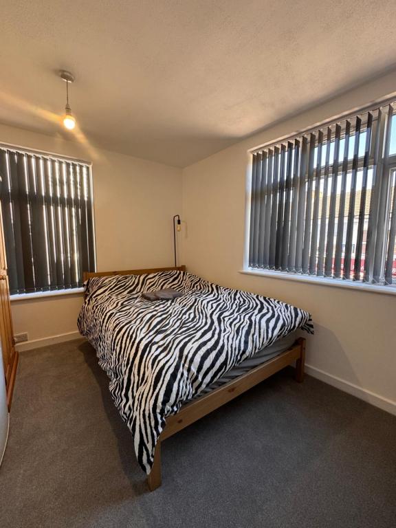 a zebra print bed in a room with windows at Serenity LTD in Leicester