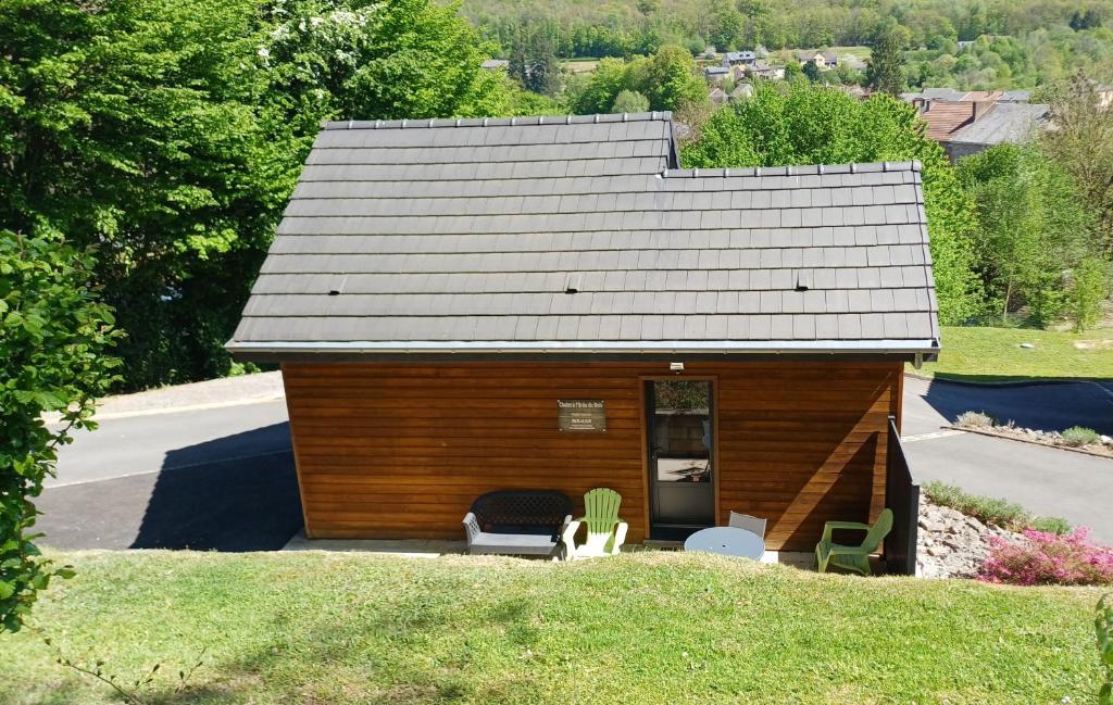 a small house with a roof on a lawn at Chalet à L'orée du bois avec parking in Tournavaux