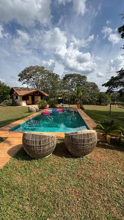 a swimming pool with two frisbees in a yard at Chácara com Piscina, Hidro, Campo de futebol, Beach Tennis, Sinuca e Churrasqueira in Analândia