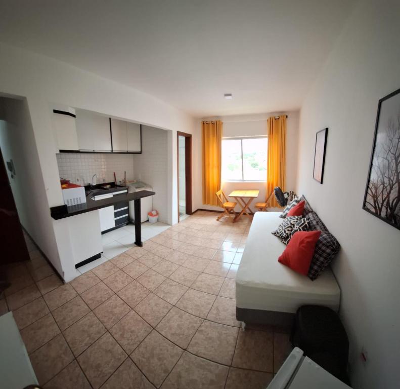 a living room with a couch and a kitchen at Loft central, cozinha e sala in Joinville