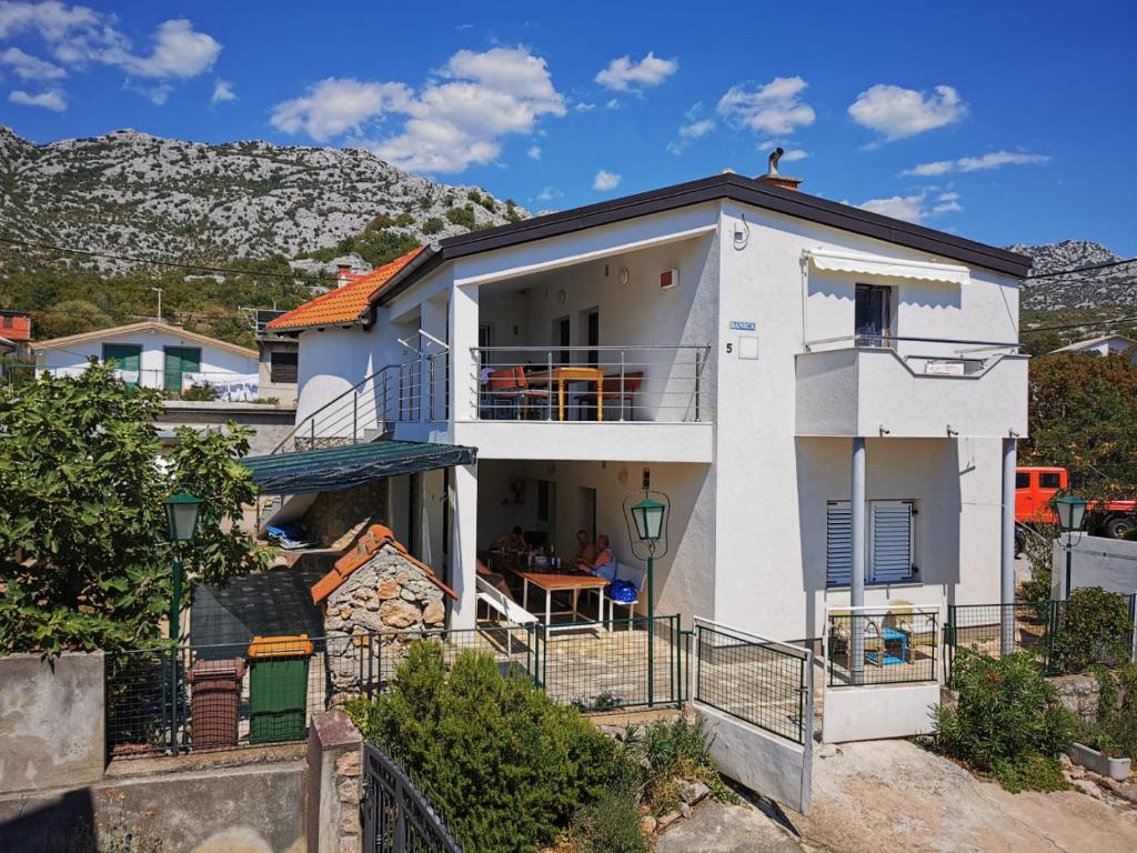 a white house with a hill in the background at Danica Karlobag in Karlobag