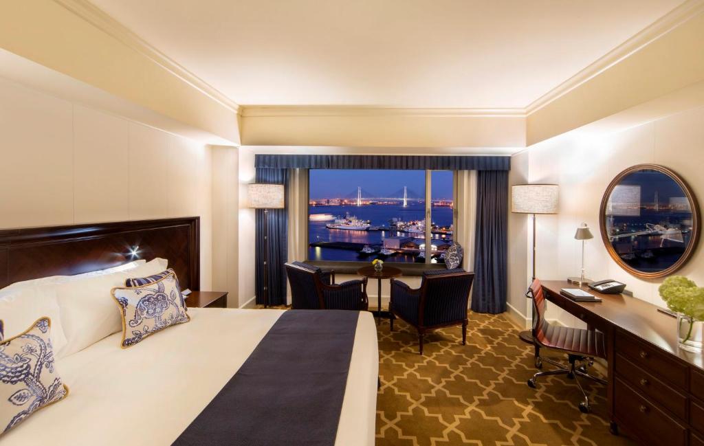 a hotel room with a bed and a desk and a window at InterContinental Yokohama Grand by IHG in Yokohama