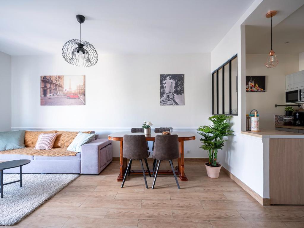 a living room with a couch and a table at appartement 15min de Paris in Drancy