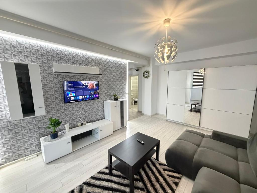 a living room with a couch and a tv on a wall at RC RelaxApart 15 in Dudu