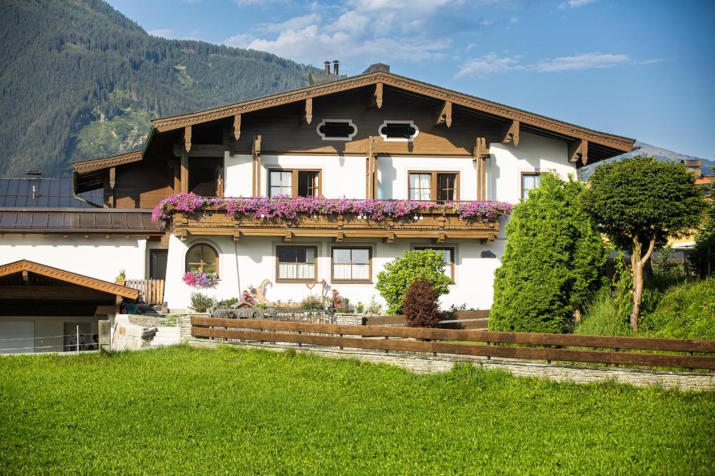 a large white house with flowers on the roof at Gästehaus Stotter in Neukirchen am Großvenediger