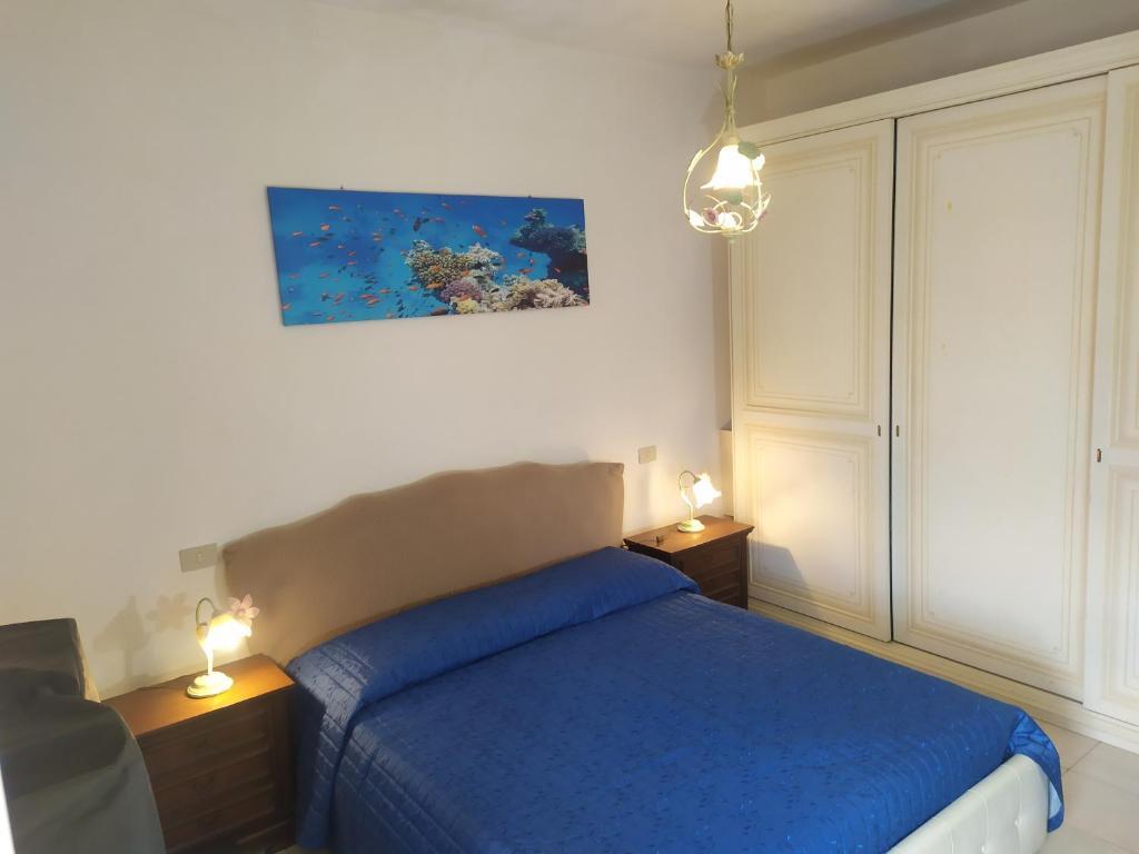 a bedroom with a bed with blue sheets and two lamps at Casa delle Onde in Vada