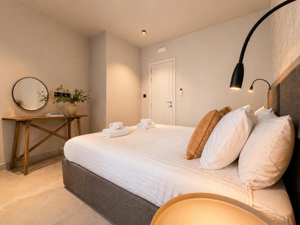 a bedroom with a large bed with white pillows at Exclusive Retreat off the Sea Front Promenade in Il-Gżira