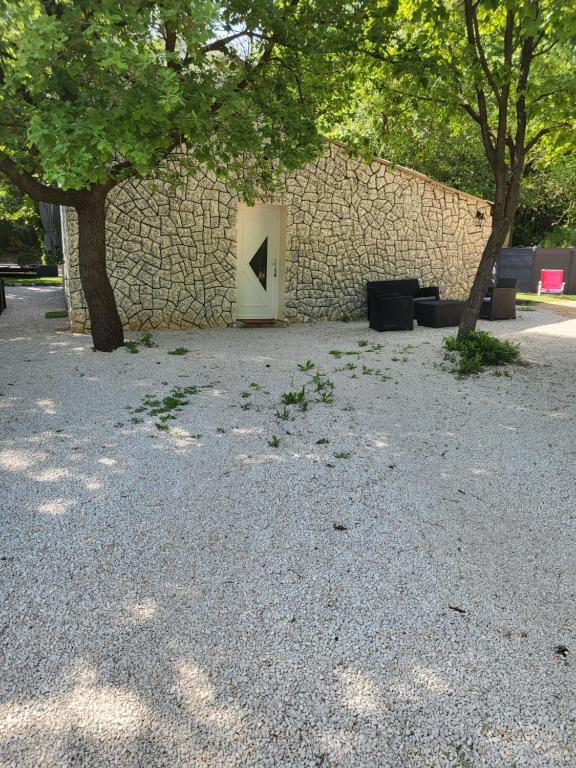 a door in a stone wall with a tree at Maison à la campagne in Tourves