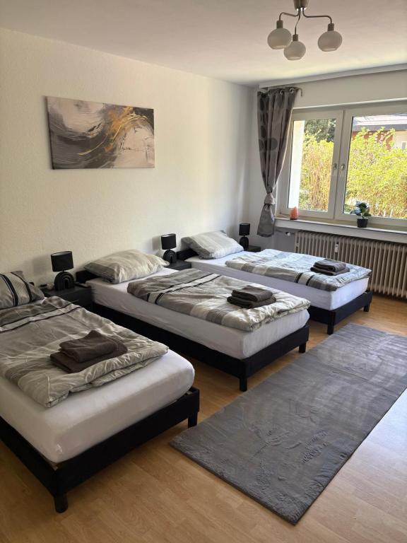 a room with three beds in a room at Rethmann Monteurwohnung Ferienwohung in Georgsmarienhütte