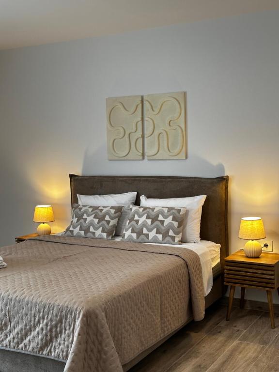 a bedroom with a large bed with two lamps at Oleana Grand Appartment in Lampi