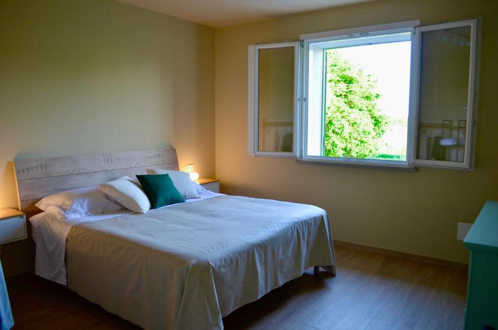 a bedroom with a bed and a window at La Papessa in Savio di Ravenna