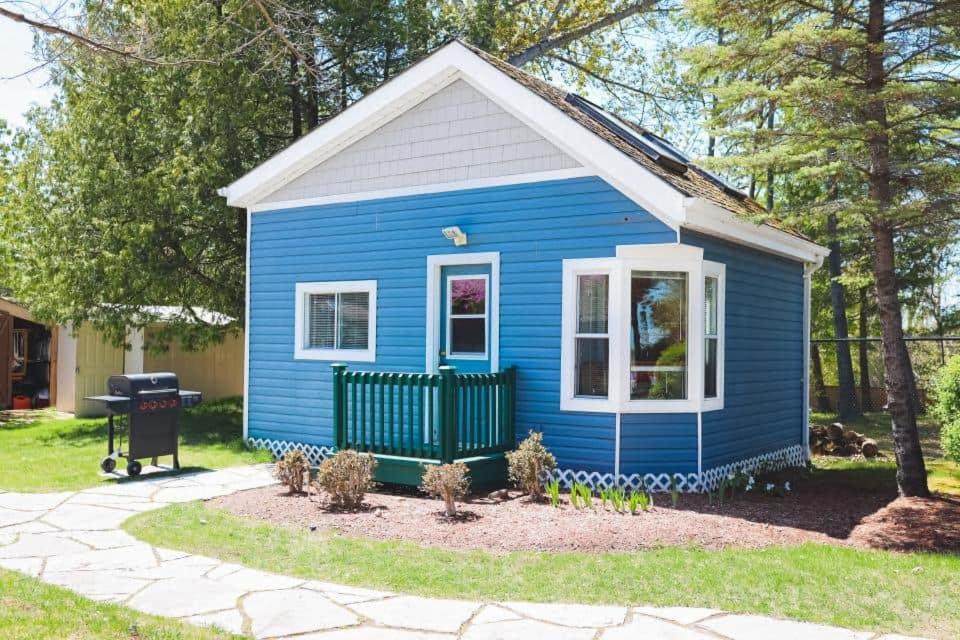 a blue tiny house in a yard at Lighthouse at Evergreen Resort in WB in Wasaga Beach