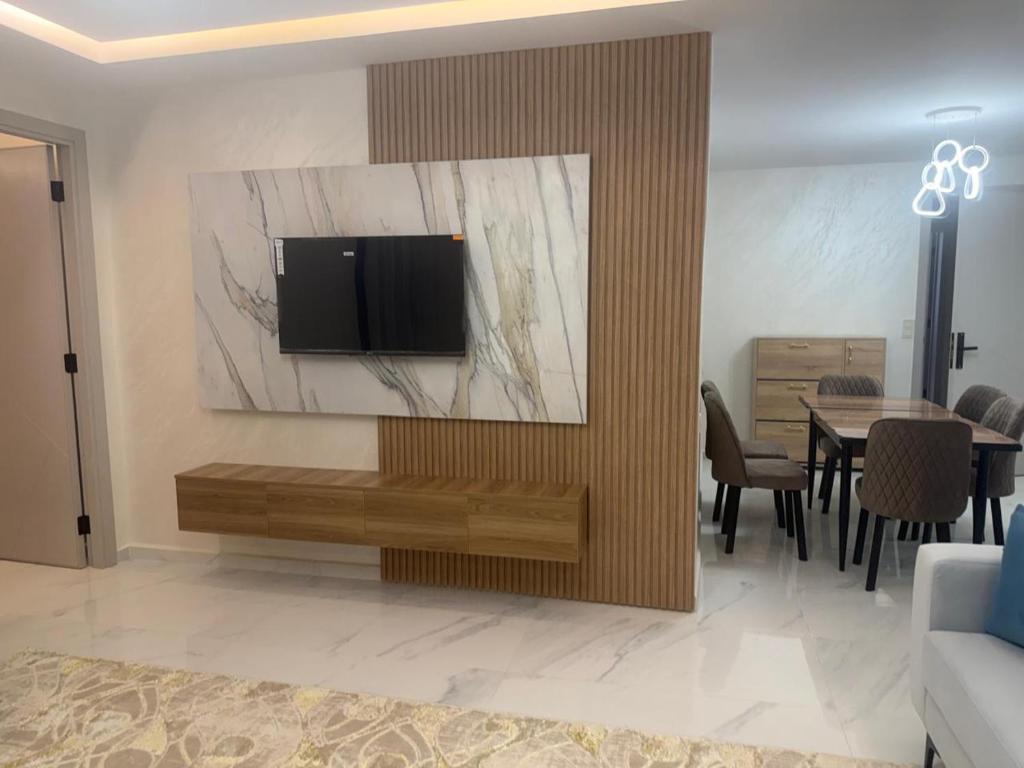 a living room with a television on a wall at tanger in Oulad Akkou
