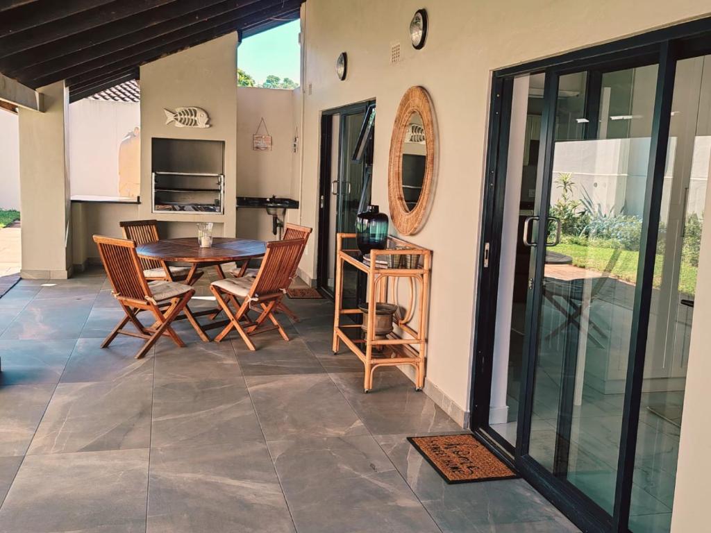 a dining room with a table and chairs at Mtunzini South Cottage in Mtunzini