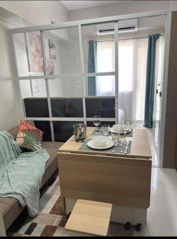 a living room with a table with glasses of wine at Dagos condo Primeworld with balcony and pool view in Mactan Island