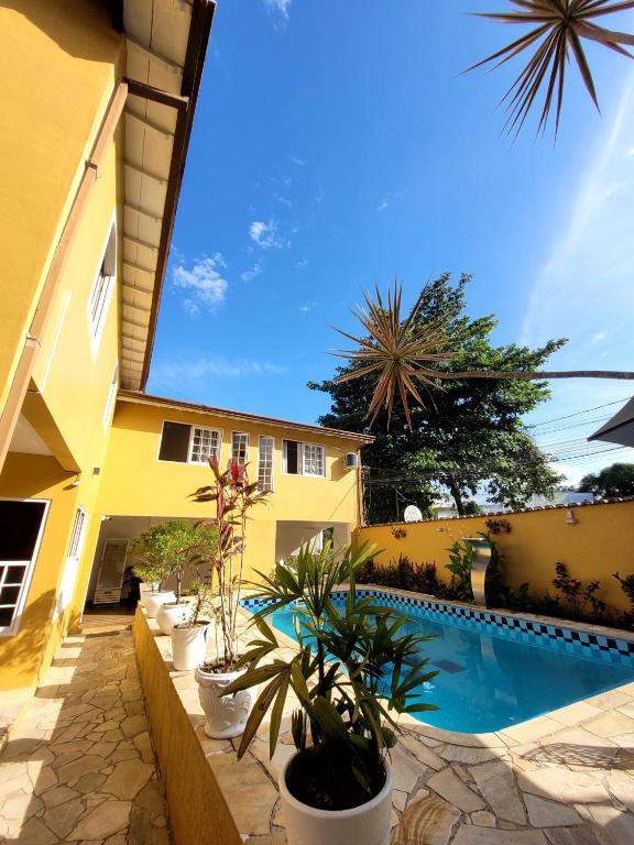 a courtyard with a swimming pool and potted plants at Pousada Casa Hospedaria in Paraty