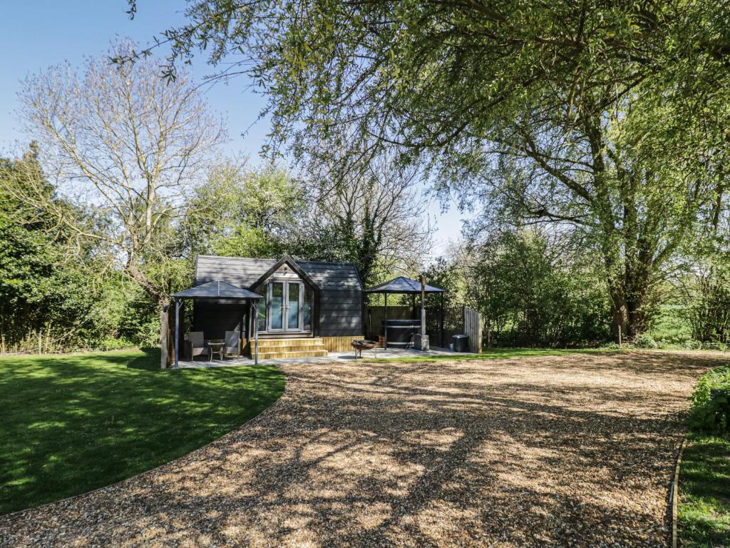 a small house in the middle of a yard at Willow Lodge At Bridge Lake Farm & Fishery in Banbury