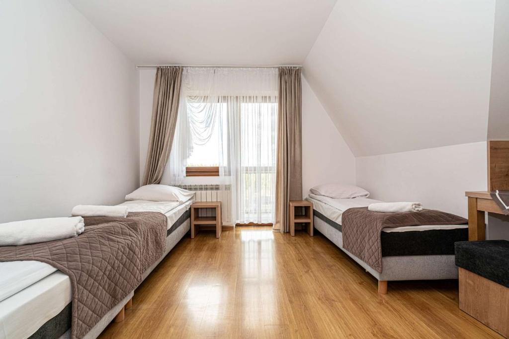 a room with three beds and a window at Pokoje gościnne u Eli i Jacka in Murzasichle