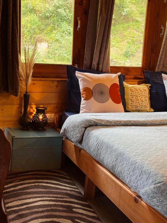 ein Schlafzimmer mit einem Bett mit blauen Kissen und einem Fenster in der Unterkunft Zoella in Gushaini