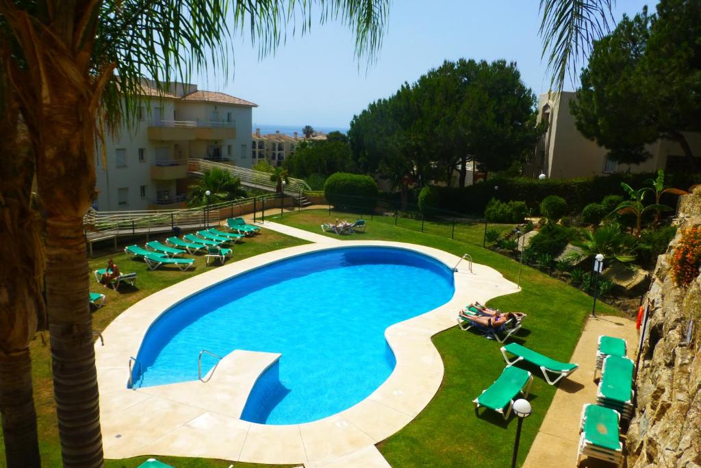 a swimming pool with lounge chairs and a resort at MARBELLA - MIJAS in Mijas