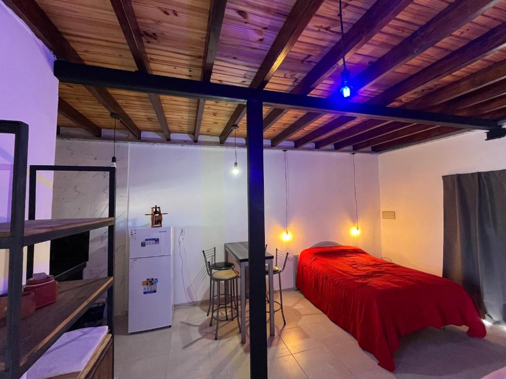 a bedroom with a bed with a red blanket at La Bodeguita in Trinidad