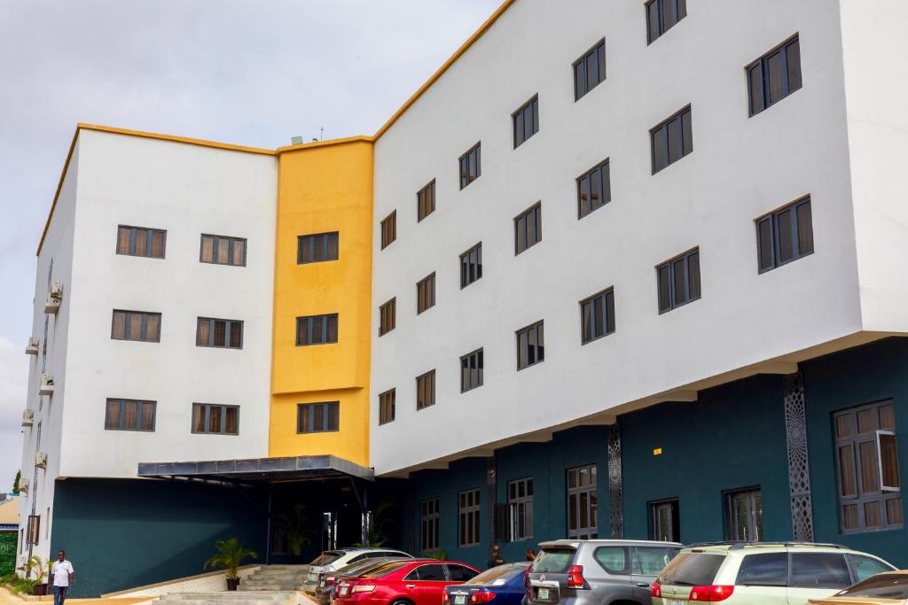 a building with cars parked in a parking lot at Diplomats Enclave Suites in Jikoyi