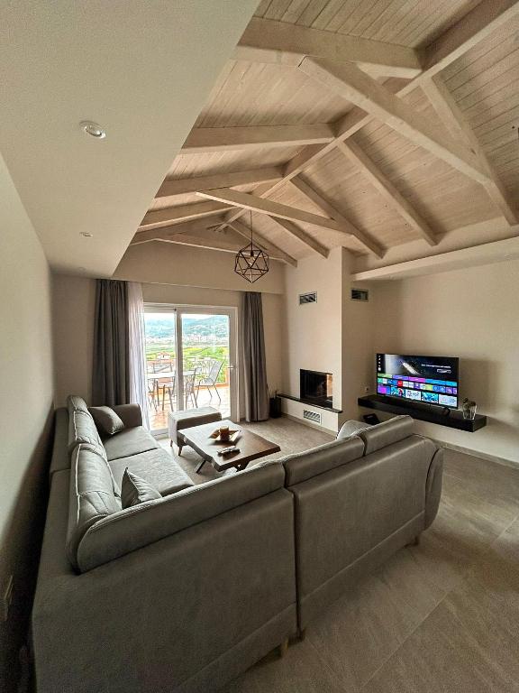 a living room with a couch and a tv at Golden View Berat, 3BR Apartment with Castle View & Parking in Berat