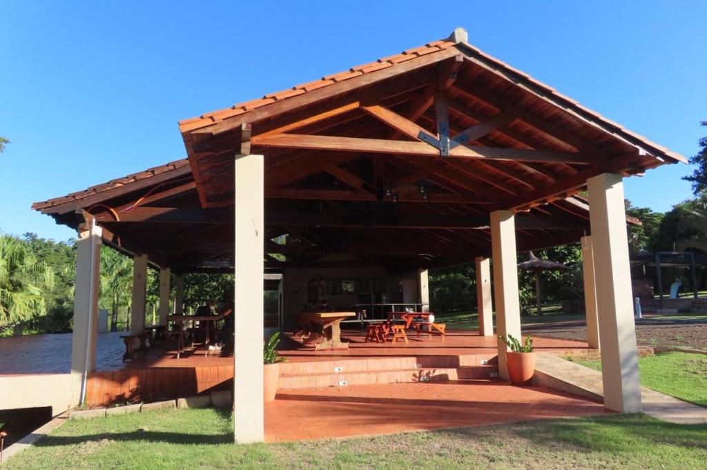 a wooden pavilion with a picnic table and tables at Amanecer del Monday in Puerto Presidente Franco