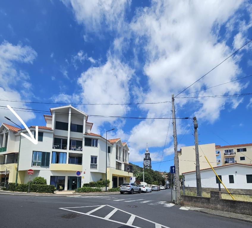 a street with a white building and a clock tower at Madeira Home Holidays in Caniço