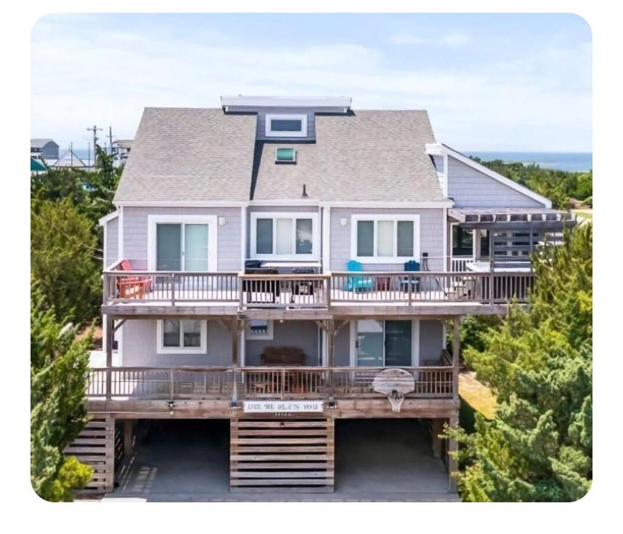 a large white house with a large deck at Isle be sea'n you in Rodanthe