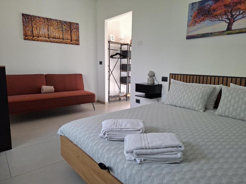 a bedroom with a bed with towels on it at The One Malpensa Rooms in Vizzola Ticino
