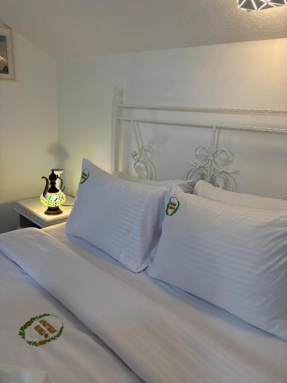 a bed with white sheets and pillows on it at Apartman Senka in Budva