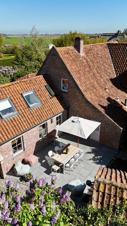 a house with a patio with a table and an umbrella at Tidal Nest - North Sea Stays in Wenduine
