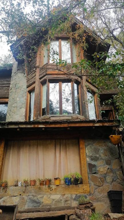 a house with windows and potted plants on it at Hostal Nunatak in La Porteña