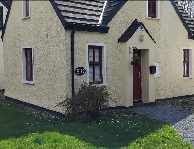 a house with a red door and a sign on it at Clifden Glen House in Clifden