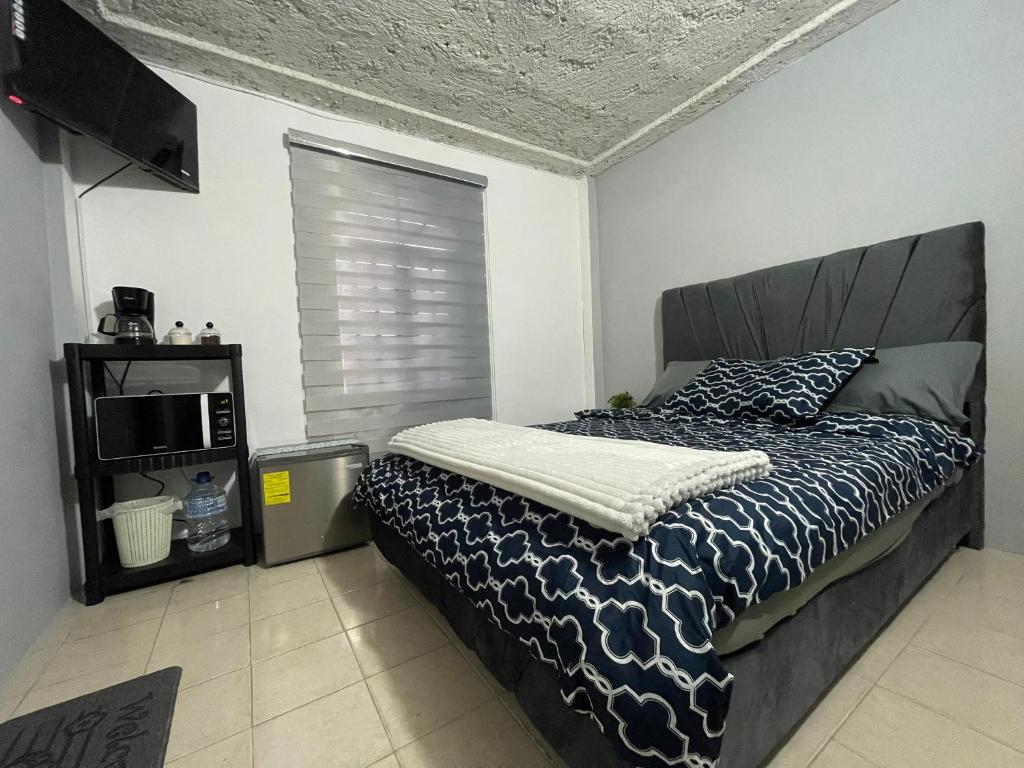 a bedroom with a bed and a tv in a room at Suite De Descanso En Urbanización Residencial FRENTE AL AEROPUERTO in Maiquetia