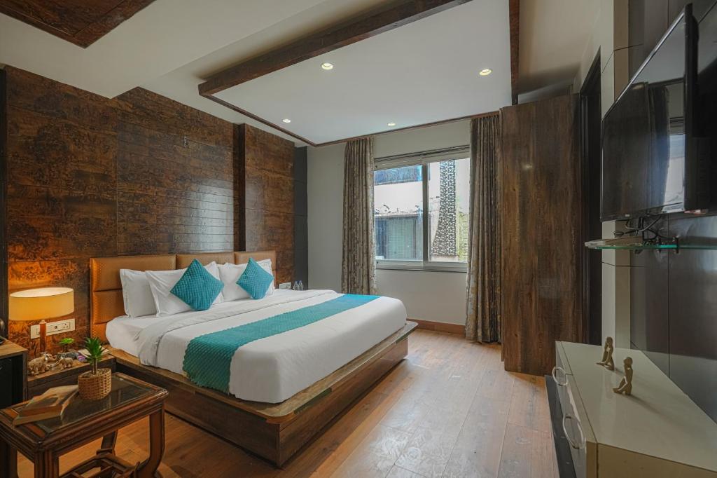 a bedroom with a large bed and a television at Hotel Heritage Street ! 100m from Golden Temple ! Parking & Restaurant in Amritsar