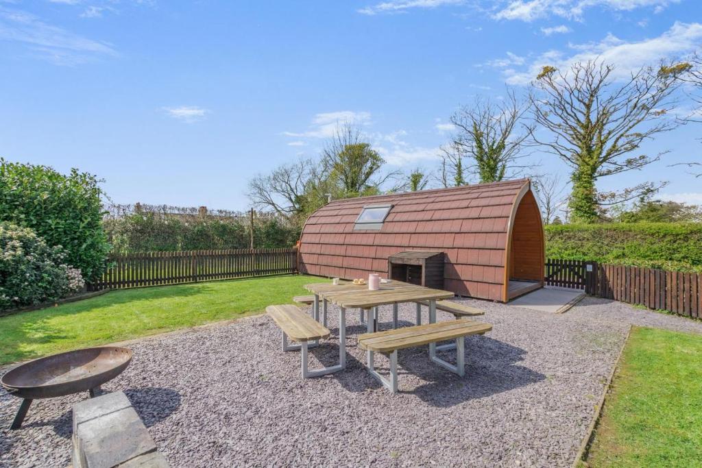 a backyard with a wooden hut with a table and benches at 1 Bed in Barnacre oc-b34348 in Catterall