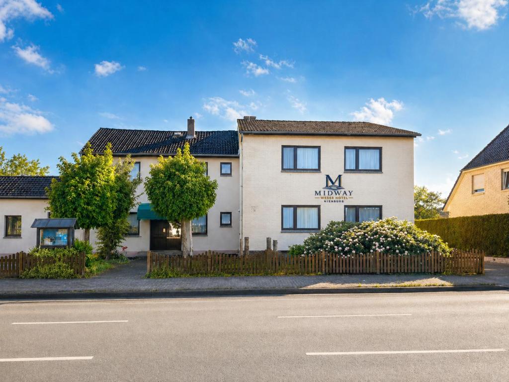 a white building with a monday sign on it at Midway Weser Hotel Nienburg in Nienburg