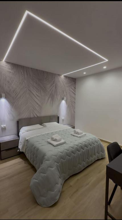 a white bedroom with a large bed with a large white ceiling at Elled-home in Misterbianco