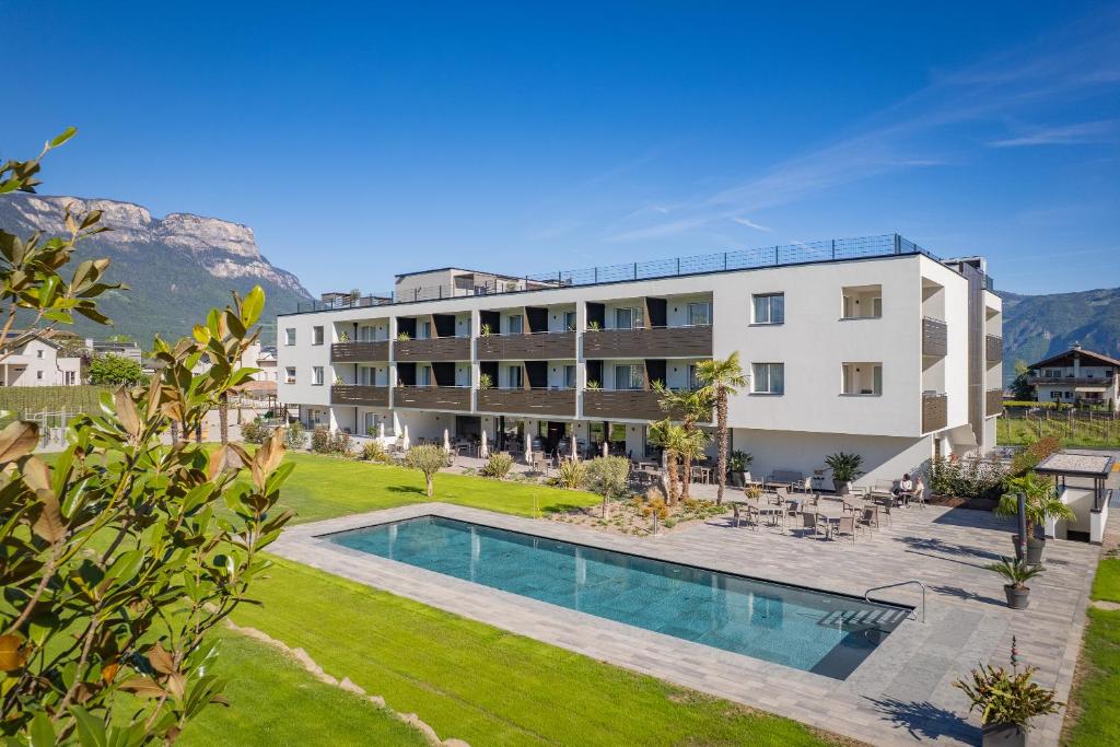 ein Mehrfamilienhaus mit Swimmingpool und Garten in der Unterkunft Hotel Cornelian Suites & Rooms in Appiano sulla Strada del Vino