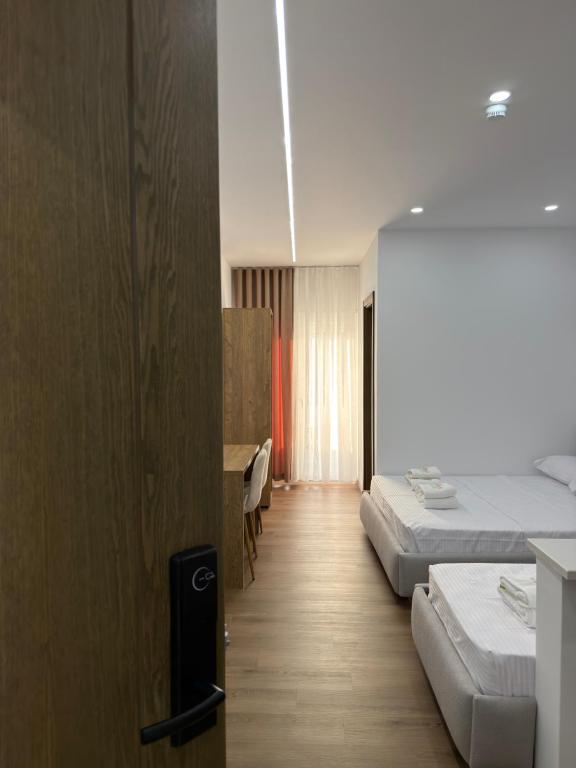 a hotel room with two beds and a desk at Petro Rooms and View in Laç
