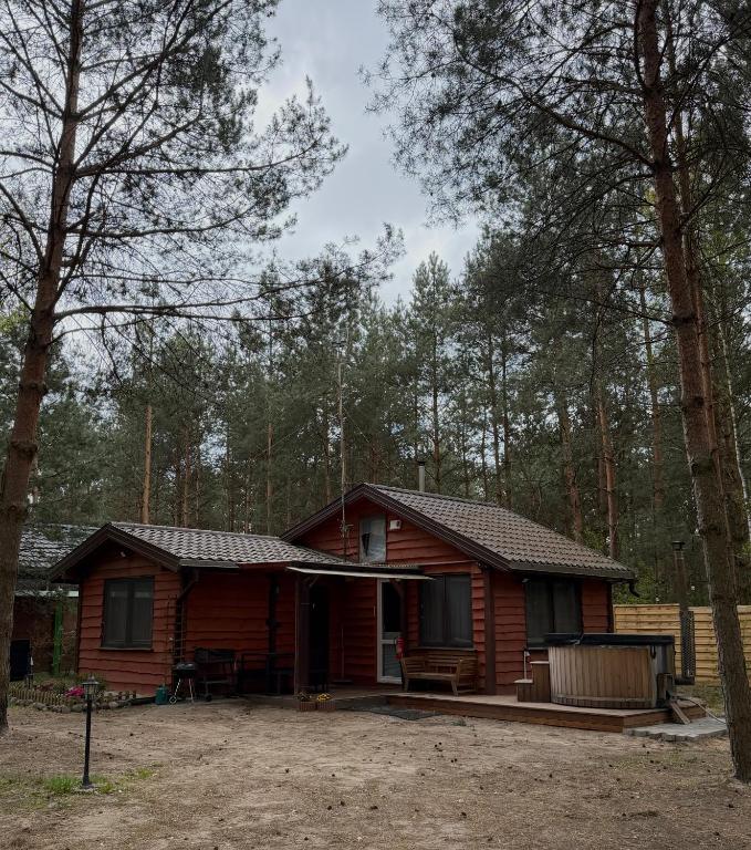 a log cabin with a porch in the woods at Leśna Chata in Kamieńczyk
