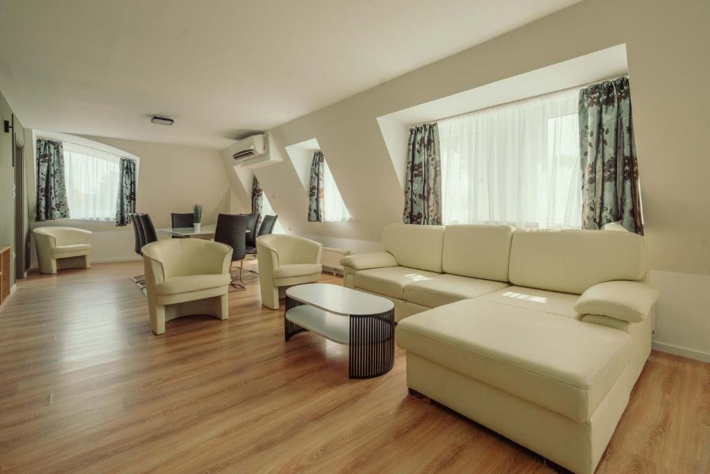a living room with a couch and chairs at Caesar Apartments & Rooms in Siófok