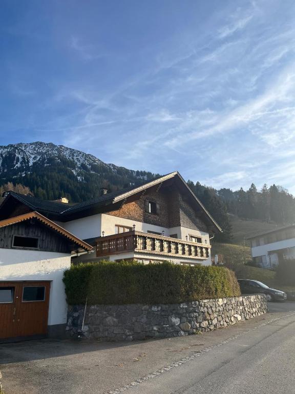 a building with a stone wall next to a street at Haus Heim in Raggal