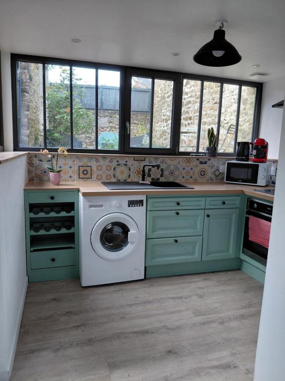 a kitchen with a washer and dryer in it at Comme à la maison in Ernée